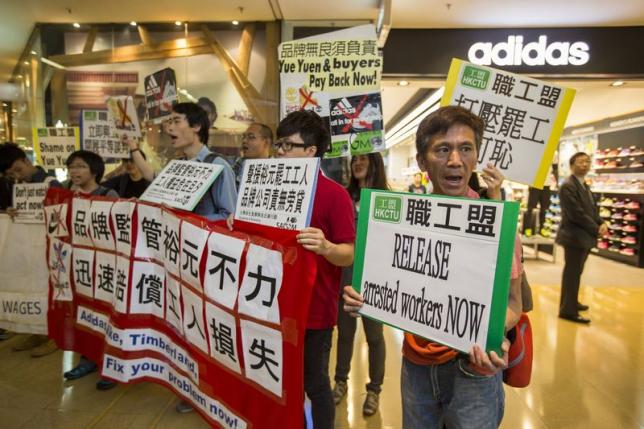 Protesters from labour organizations shout slogans in support of the strike by workers at a Yue Yuen Industrial Holdings Ltd shoe factory complex in Dongguan, at a shopping mall in Hong Kong April 24, 2014. REUTERS/Tyrone Siu